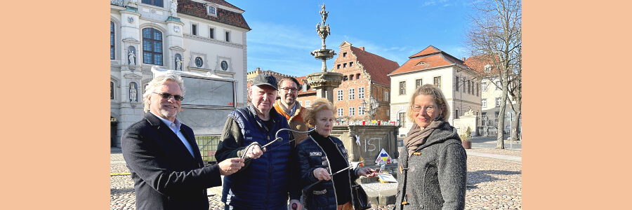 Die Spender:innen (v.l.) Philipp von Stumm, Roswitha Meyer Ebeling, Konrad Gelinsky und Jan Konrad Gelinsky übergeben symbolisch Pfeil und Bogen an Maja Lucht, Leiterin der Gebäudewirtschaft der Hansestadt Lüneburg.