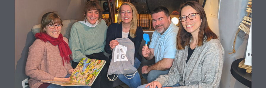 Foto: mosaique. Antje Blumenbach von der Provinzperle (Mitte) präsentiert eine der Welcomebags zusammen mit Eva Kern und Corinna Krome (mosaique - Haus der Kulturen), Jan-Rasmus Lippels (Junge Lüneburger e.V.) und Julia Peckmann (v.l.n.r.). 