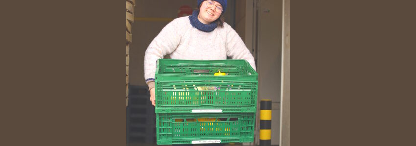 Foto: Foodsharing. Foodsaverin bringt Kisten mit Lebensmitteln zum Fairteiler.