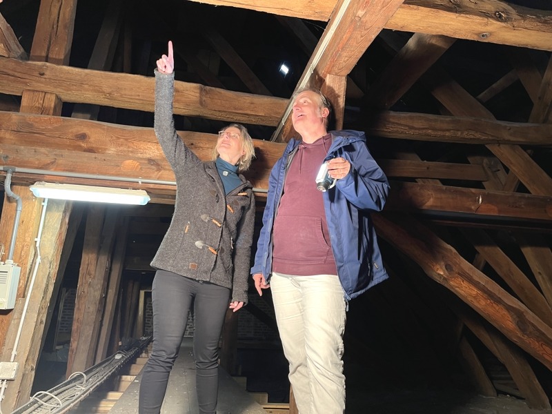Maja Lucht (Fachbereichsleitung Gebäudewirtschaft) und Dipl.-Ing. Frieder Küpker (Projektleiter) machen sich im hölzernen Dachtragwerk über dem Fürstensaal ein Bild von der Situation. Foto: Hansestadt Lüneburg.