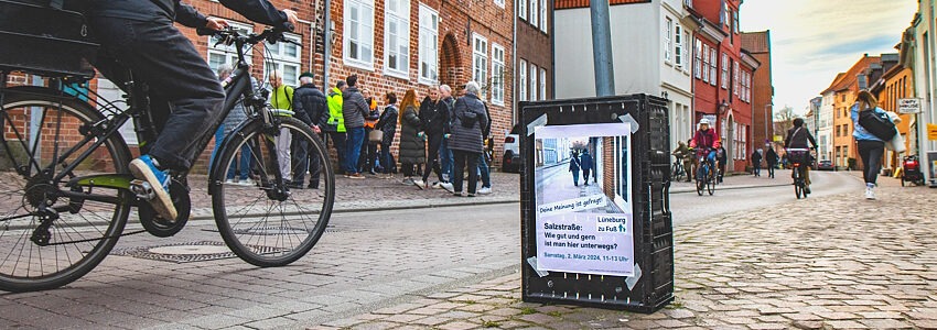 Einfahrt in die Salzstraße von der Neuen Sülze aus. Links Mitglieder der AG und Interessierte im Gespräch. Aktion AG Lüneburg zu Fuß, 2. März 2024. Foto: Malte Hübner.