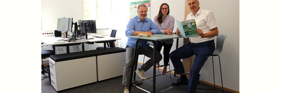 Foto: Landkreis Lüneburg. Janna Hoveida (Fachdienstleitung Klimaschutz/ Kreisentwicklung/ Wirtschaft), Dr. Jürgen Glaser (Süderelbe AG) und Remo Röntgen (Connect Circular e. V.) testen die C2C-Möbel.