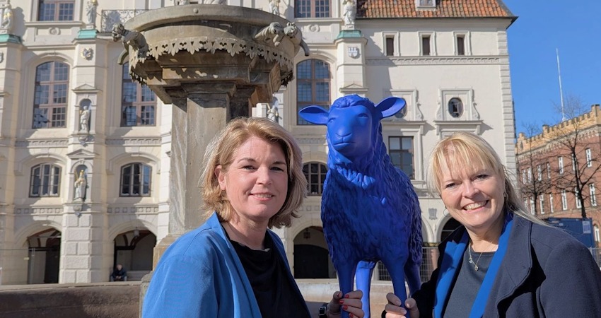 Lüneburgs Oberbürgermeisterin Claudia Kalisch (l.) und Melanie-Gitte Lansmann, Geschäftsführerin der Lüneburg Marketing GmbH, mit einem der Schafe aus der blauen Friedensherde. Foto: Hansestadt Lüneburg
