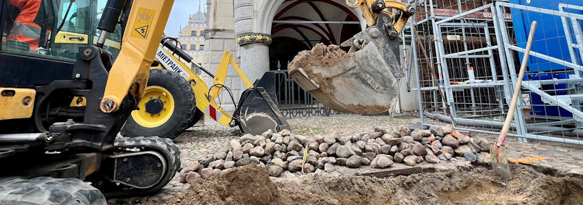 Foto: Hansestadt Lüneburg. Mit dem Kleinbagger wird vor dem Rathaus aufgegraben, um Fundamente für eine Notabstützung vorzubereiten.
