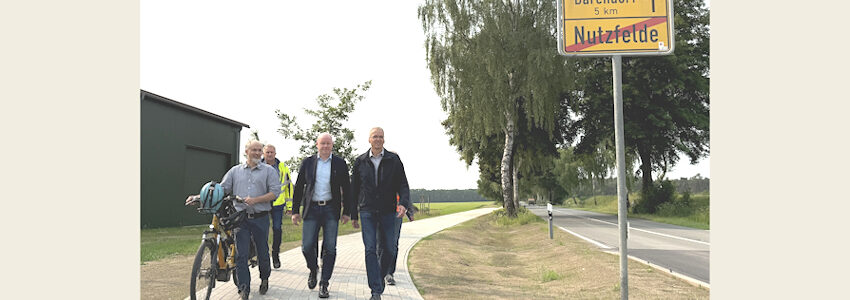 Foto: Landkreis Lüneburg. Schritten gemeinsam den neuen Radweg entlang der K28 ab (von rechts): Landrat Jens Böther, Laars Gerstenborn (Samtgemeindebürgermeister der Samtgemeinde Scharnebeck), Raino Fraedrich (Betrieb Straßenbau und -unterhaltung) und Tobias Winkelmann (Fachdienst Mobilität beim Landkreis Lüneburg). Foto: Andreas Tamme.