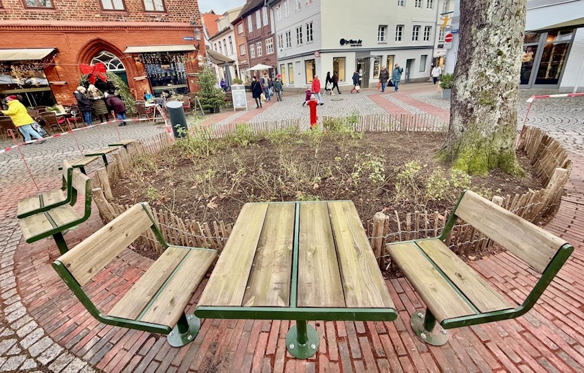 Foto: Hansestadt Lüneburg.  Die neuen Sitzmöbel am Schrangenplatz. Das Flatterband wird entfernt, sobald der Kleber ausgehärtet ist. 