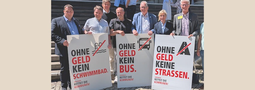 Foto: NLT. Ohne Geld kein Schwimmbad, kein Bus, keine Straßen: Auch die Verantwortlichen im Landkreis Lüchow-Dannenberg beteiligten sich an der Übergabe der Resolution "Rettet die Kommunen!" am 27. Mai 2026 an Ministerpräsident Olaf Lies. Von links: Samtgemeindebürgermeister Christian Järnecke, Bürgermeister Kurt Behning, Erster Kreisrat Simon Schermuly, Samtgemeindebürgermeister Sascha Liwke, Samtgemeindebürgermeister Jürgen Meyer, Landrätin Dagmar Schulz, Bürgermeister Holger Mertins.