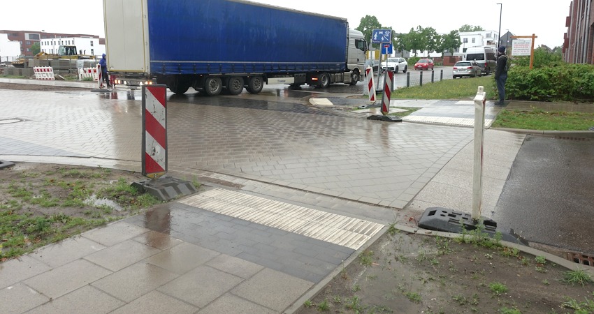 Foto: Uwe Wenk, 26.04.2026. Im Vordergrund ist der Gehweg beim Signalfeld plan abgesenkt. Es folgt darauf allerdings ein erhöhte Kante. Auf der gegenüberliegenden Seite fehlt die Nullabsenkung wieder.