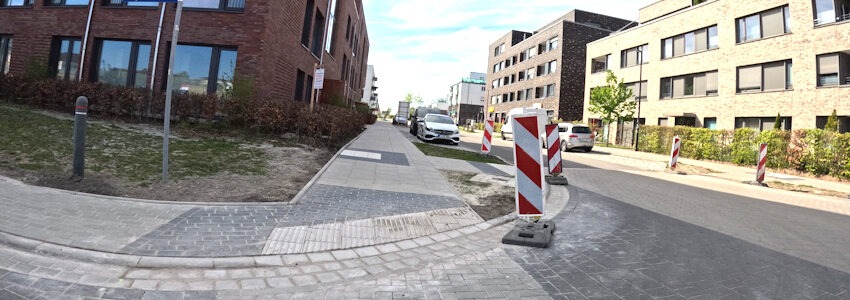 Foto: Uwe Wenk, 26.04.2026. Einmündung der Lübecker Straße in die Marga-Jess-Straße. Hier ist der Gehsteig vollständig abgesenkt. Wer mit Rollstuhl oder Rollator unterwegs ist, kann die Straße barrierefrei queren.