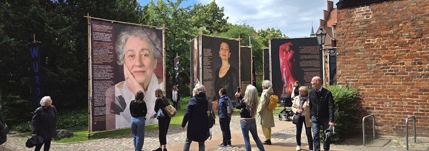Foto: Lüne-Blog. Die Ausstellung „WÜRDE!“ ist vom 9. bis 18. Juni 2026 im Rathausgarten Lüneburg zu sehen: Großformatige Porträts von Frauen mit Zuwanderungsgeschichte und persönliche Statements setzen ein Zeichen für Würde und gesellschaftliche Teilhabe.