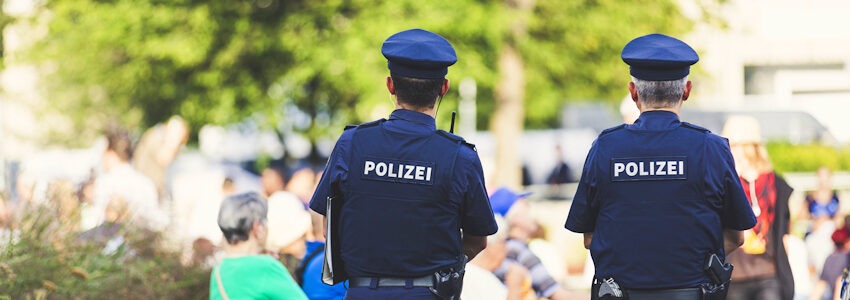 Foto: Markus Spiske, Pixabay. Zwei Polizeibeamte von hinten in einem Park.