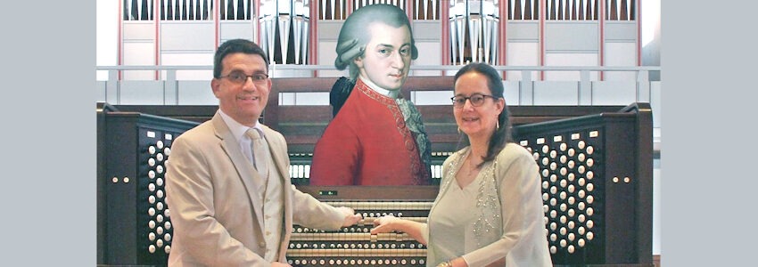 Foto: Orgel-Duo Lenz. Iris und Carsten Lenz an der Orgel vor einem Bild von Mozart.